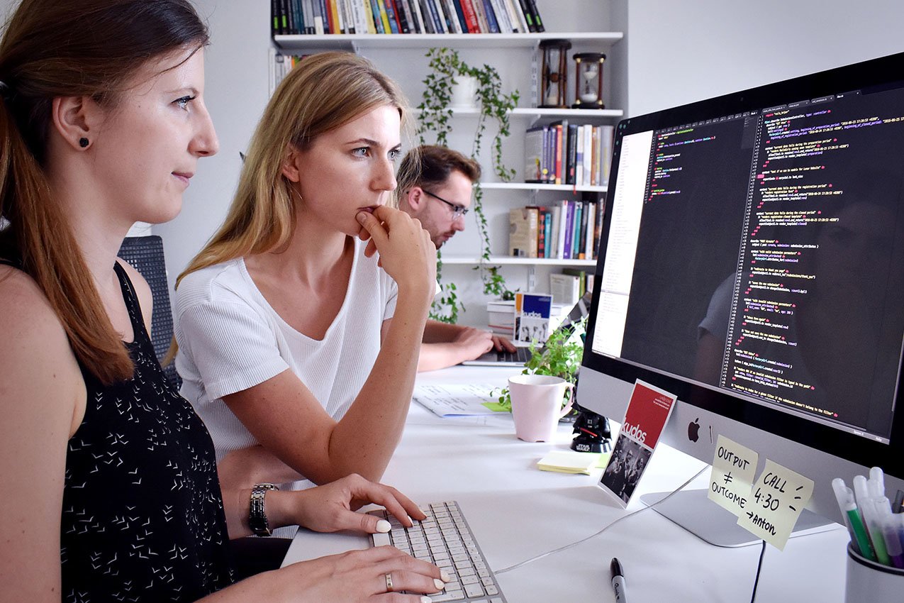 Pair programming developers working together in front of a monitor